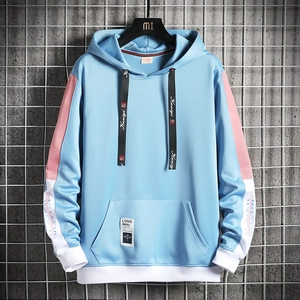 Détail d'un sweat à capuche color-block bleu et rose avec cordon et poche logo