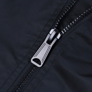 Detailed close-up of matte charcoal metal zipper and fine black fabric on bomber jacket