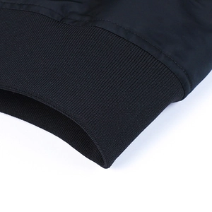Detail shot showing the elastic ribbed cuffs and black matte fabric of the bomber jacket