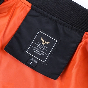 Detail of MA-1 bomber jacket interior featuring orange lining and military spec label