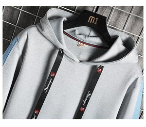 Détail du sweat à capuche gris et bleu clair avec manches contrastées et cordon