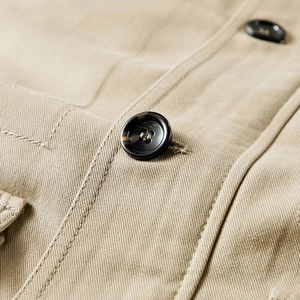Detail der khakifarbenen Twill-Baumwolljacke mit Schildpattknöpfen und Doppelnaht