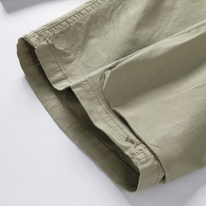 Detailed close-up of double-stitched hem on olive green cargo shorts for men