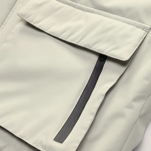 Detailaufnahme der grauen Funktionsjacke mit großer Klappentasche und wasserdichtem Zipper