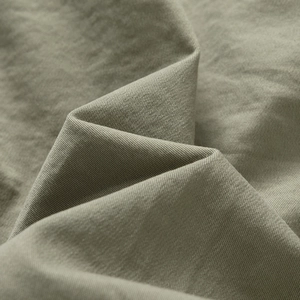 Macro shot of olive cargo shorts fabric showing detailed twill weave and cotton texture