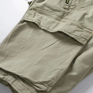 Close-up of olive green cargo shorts featuring side pockets with fashion label