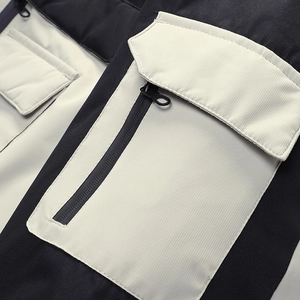 Detailansicht der Reißverschlusstasche an der Outdoorjacke mit Farbblock und Textur