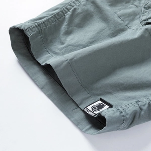 Detail view of the cotton cargo shorts leg showing double stitching and fashion woven label