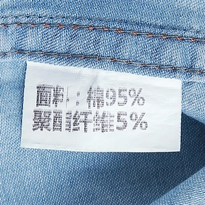 Macro detail of the denim shirt washing label showing 95% cotton and 5% polyester fabric blend
