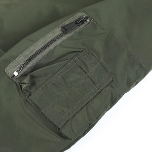 Dettaglio della tasca con zip e asole per penne sulla manica del bomber verde militare