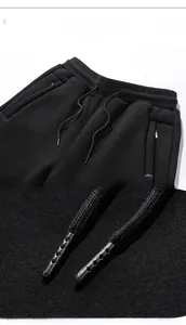 Close-up of black joggers showing elastic waistband and metal tip drawstring detail