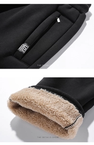 Detail view of winter black sweatpants showing sherpa fleece lining and zipped pocket