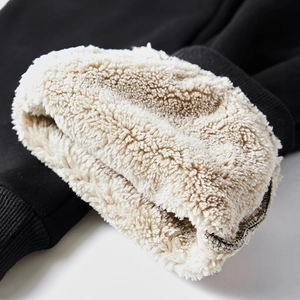 Macro shot of thick beige lamb wool lining and black ribbed cuffs for thermal insulation