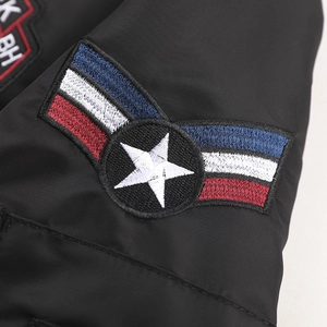 Dettaglio ravvicinato del ricamo premium sulla giacca bomber nera con emblema stella