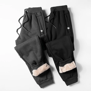 Detail view of thick sherpa fleece lining inside men's winter joggers in grey and black