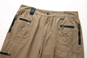Detailansicht der khakifarbenen Cargo-Hose mit Metallreißverschlusstaschen und Gürtelschlaufen