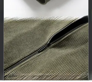 Detail of army green corduroy jacket hem with neat stitching and metal zipper