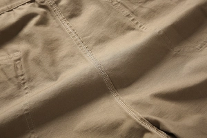 Makroaufnahme von khakifarbenem Baumwoll-Twill mit verstärkter Doppelnaht-Verarbeitung