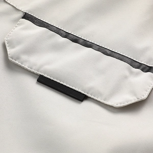 Detail of outdoor jacket pocket with grey contrast webbing and high-quality stitching texture