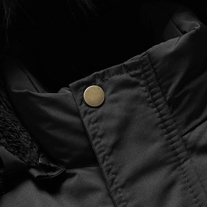 Dettaglio del parka invernale nero con bottone a pressione in bronzo e fodera in pelliccia