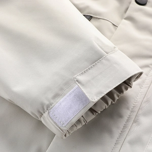 Detail of light beige outdoor jacket sleeve with adjustable velcro cuff and elastic hem