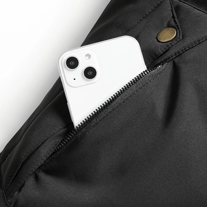 Dettaglio di parka nero con tasca a zip e bottone in bronzo in stile vintage