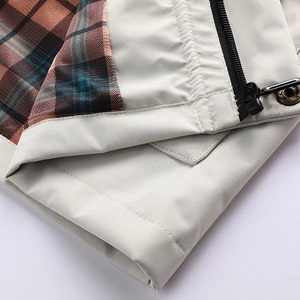 Detail of outdoor jacket with beige technical fabric and vintage plaid lining with zipper