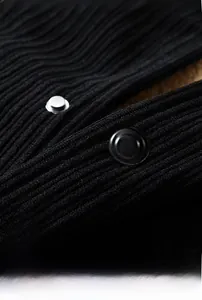Detail of black corduroy fabric texture and shiny round buttons on a winter jacket