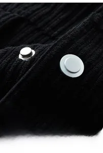 Detail of 3D metallic buttons on premium black corduroy jacket fabric with fine texture
