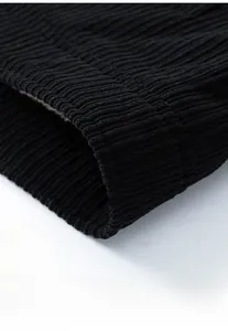 Macro shot of the ribbed hem and professional stitching on this black corduroy jacket