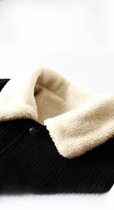 Detail view of winter corduroy jacket with white sherpa collar and black button closure