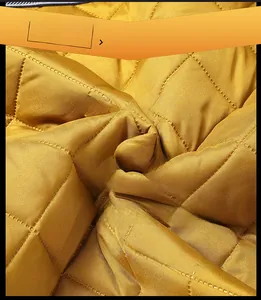 Close-up of golden quilted fabric with diamond stitching for warm winter thermal jackets