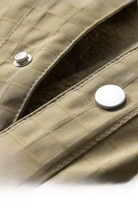 Close-up of khaki plaid jacket with metallic silver buttons and warm fleece lining