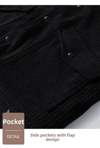 Detail of black corduroy jacket showing a flap pocket with a matching metal snap button