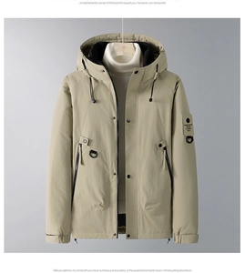Close-up of khaki hooded jacket featuring utility pockets and tactical arm patch