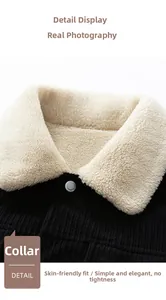 Detail of black corduroy jacket with soft cream fleece collar and metallic snap button