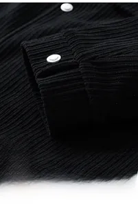 Close-up of black corduroy jacket cuffs with premium silver metal buttons detail