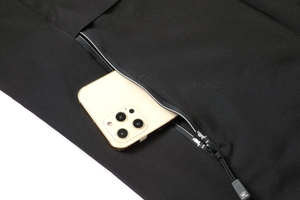 Detail of waterproof zipper pocket on black winter parka showing large storage capacity