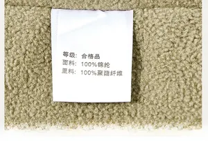 Close-up of the care label and plush fleece texture on a khaki outdoor jacket