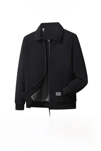 Detalle de chaqueta de pana negra con puños acanalados y parche de logo de moda