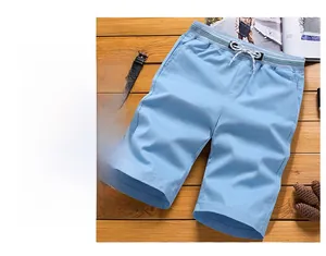 Detail view of light blue casual shorts with elastic drawstring waist on wood surface