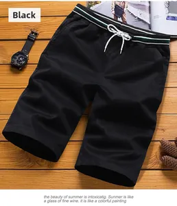 Detail of black summer shorts with elastic drawstring waist and striped tape on wood background