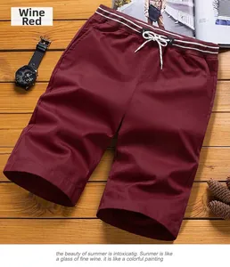 Detail view of wine red men's casual shorts with drawstring waist on wooden background