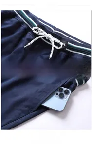 Detail of navy cotton shorts featuring striped elastic waistband and large side pockets