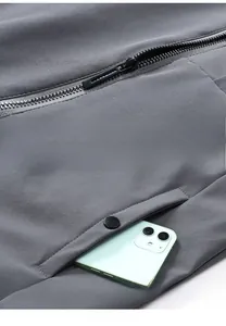 Detail view of smooth metal zipper and functional buttoned pocket on a grey jacket