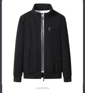 Close-up of black corduroy jacket with stand collar, metallic zipper and striped detail