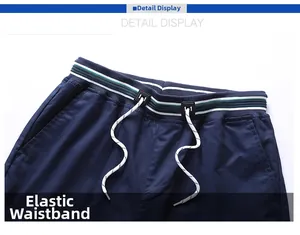 Detail view of elastic waistband with white drawstring and decorative buckle on blue shorts