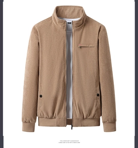 Detail view of khaki corduroy jacket showing zipper pockets and ribbed cuffs