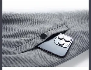 Close-up of side pocket on dark grey corduroy jacket with decorative black metal button