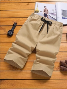 Khaki Cargo-Shorts für Herren mit elastischem Kordelzug auf rustikalem Holzhintergrund